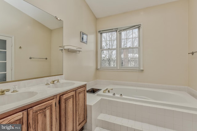 bathroom with a relaxing tiled tub, vanity, and lofted ceiling