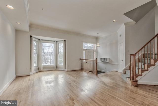 entryway with a notable chandelier, crown molding, and light hardwood / wood-style floors