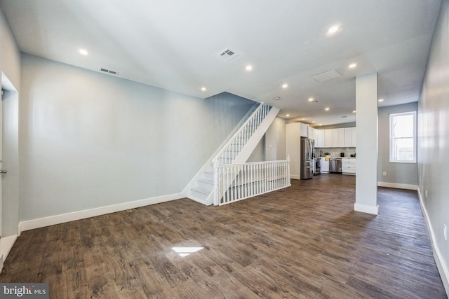 unfurnished living room with baseboards, visible vents, stairway, dark wood-style flooring, and recessed lighting