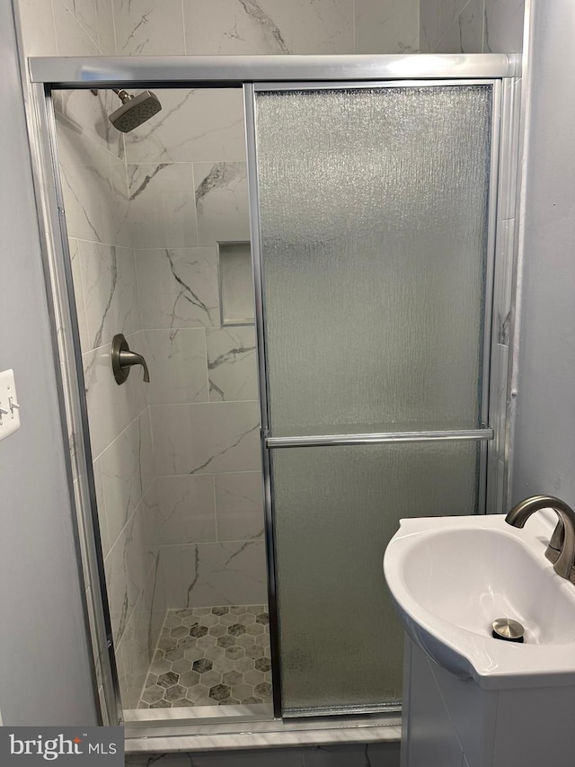 bathroom featuring vanity and a shower with door