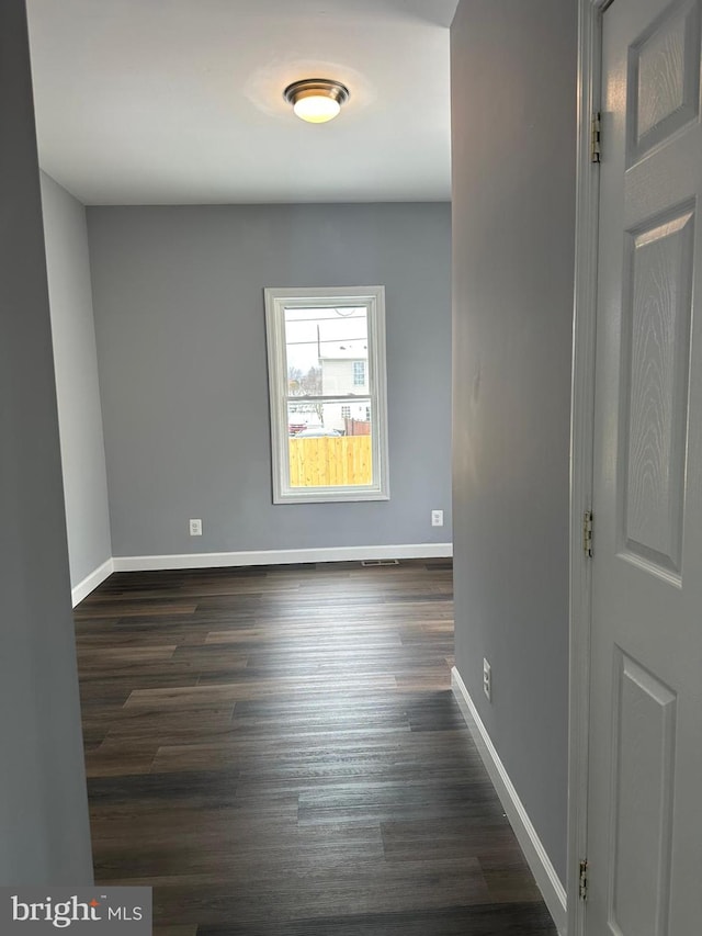 unfurnished room with dark hardwood / wood-style flooring