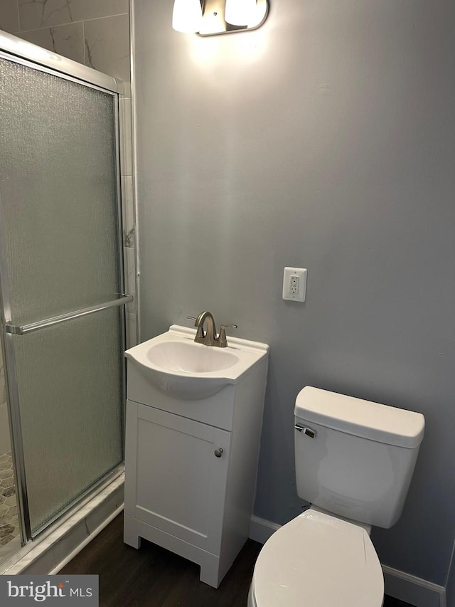 bathroom featuring vanity, toilet, and a shower with door