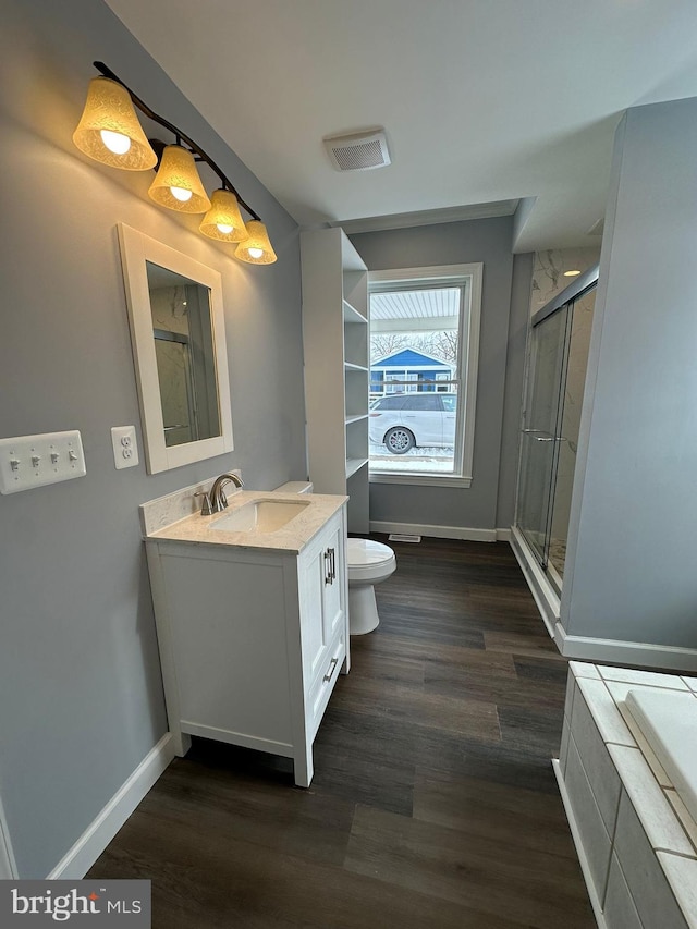 bathroom featuring vanity, toilet, a shower with shower door, and wood-type flooring