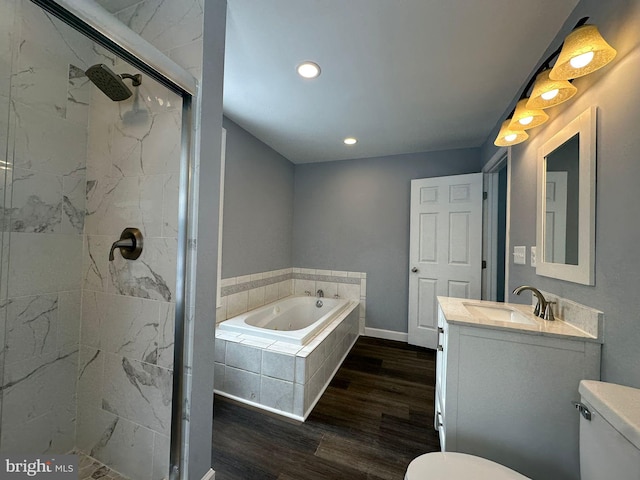 full bathroom with shower with separate bathtub, vanity, toilet, and hardwood / wood-style floors