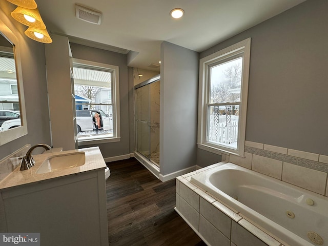 bathroom featuring hardwood / wood-style floors, vanity, and shower with separate bathtub