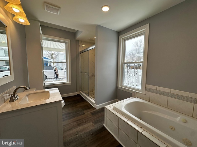 bathroom with vanity, independent shower and bath, and hardwood / wood-style flooring