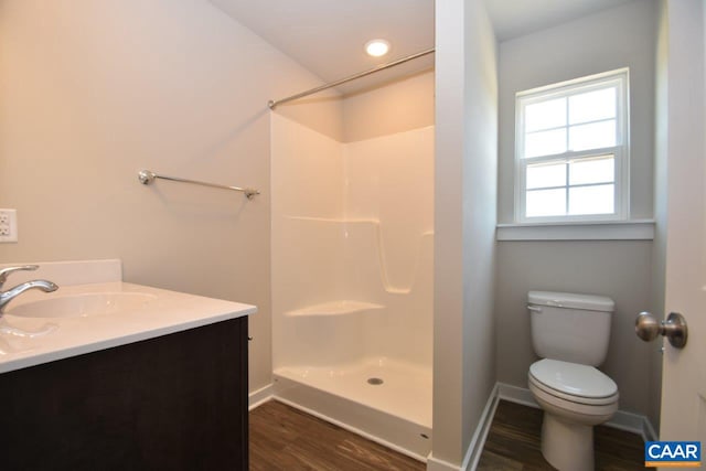 bathroom featuring a shower, hardwood / wood-style floors, vanity, and toilet