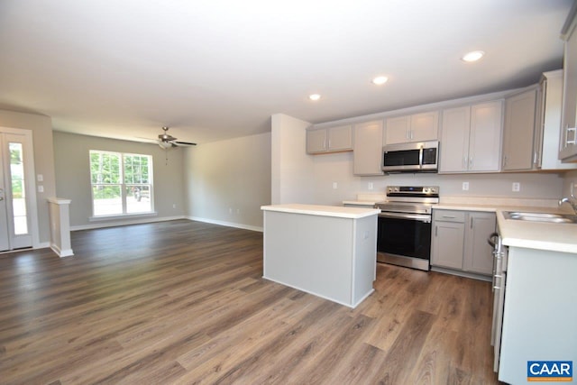 kitchen featuring a center island, sink, gray cabinets, dark hardwood / wood-style flooring, and stainless steel appliances