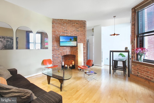 living room with a brick fireplace and light hardwood / wood-style flooring