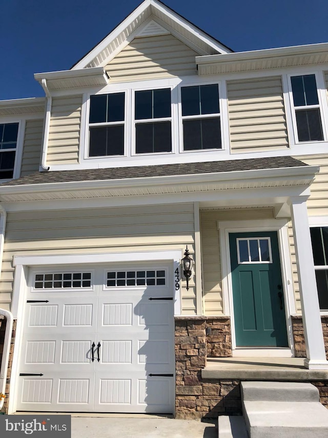 view of front facade with a garage and stone siding