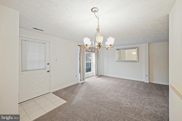 unfurnished dining area featuring light carpet, a notable chandelier, and a textured ceiling