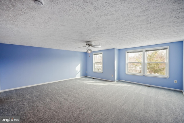 carpeted empty room with ceiling fan and a textured ceiling