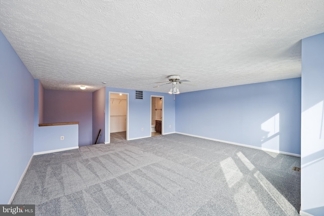 unfurnished room with a textured ceiling, ceiling fan, and carpet