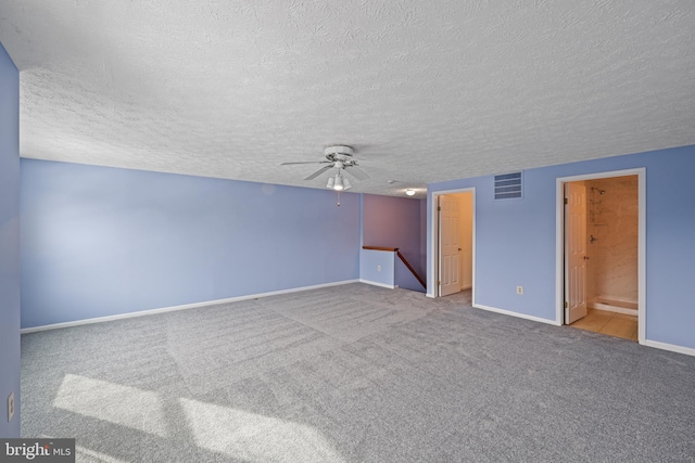 carpeted empty room featuring ceiling fan and a textured ceiling