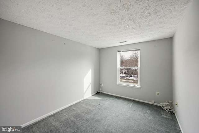 carpeted spare room with a textured ceiling