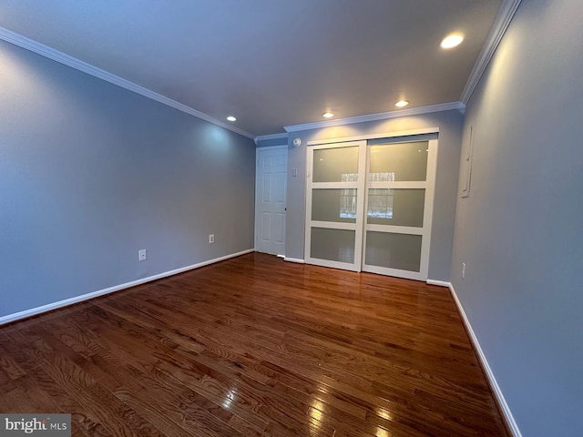 empty room with dark hardwood / wood-style flooring and ornamental molding