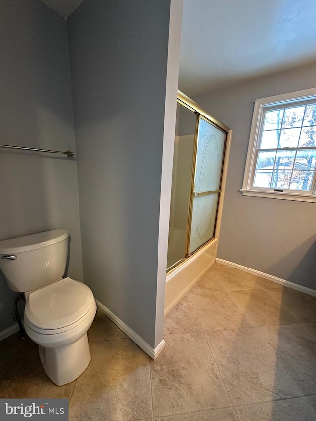 bathroom with toilet, bath / shower combo with glass door, and tile patterned floors