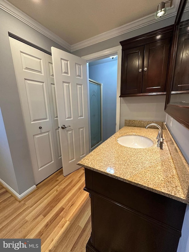 bathroom featuring sink, ornamental molding, and hardwood / wood-style flooring