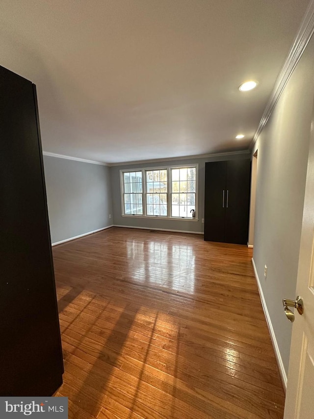 spare room featuring ornamental molding and hardwood / wood-style floors