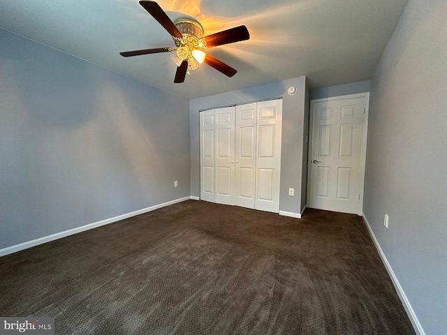 unfurnished bedroom featuring ceiling fan and dark carpet