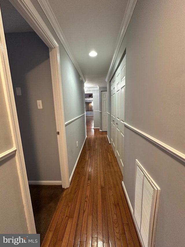 hall featuring dark wood-type flooring and ornamental molding