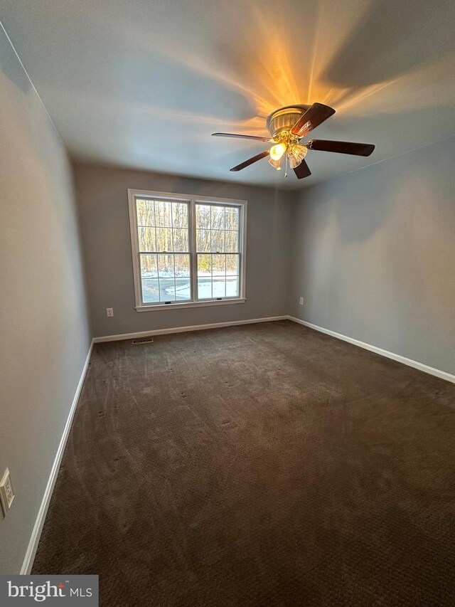 carpeted spare room with ceiling fan