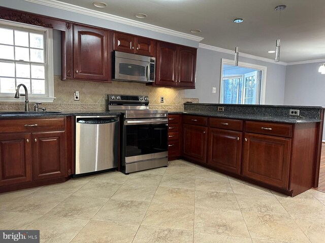 kitchen with decorative light fixtures, stainless steel appliances, sink, backsplash, and kitchen peninsula