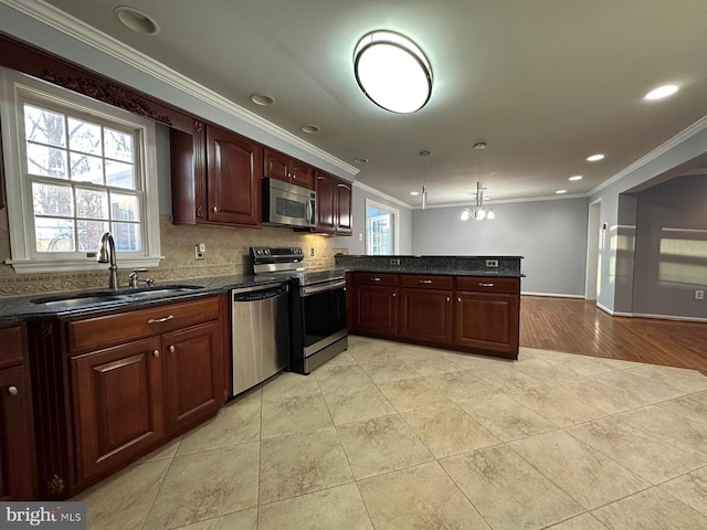 kitchen featuring decorative light fixtures, a notable chandelier, sink, stainless steel appliances, and ornamental molding