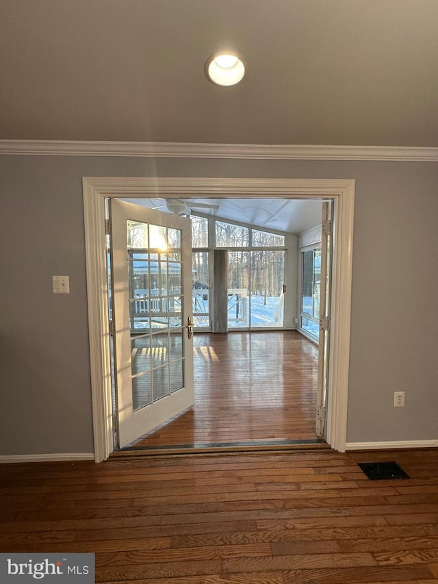 interior space with crown molding and wood-type flooring