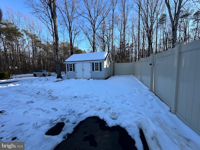 yard layered in snow featuring an outbuilding