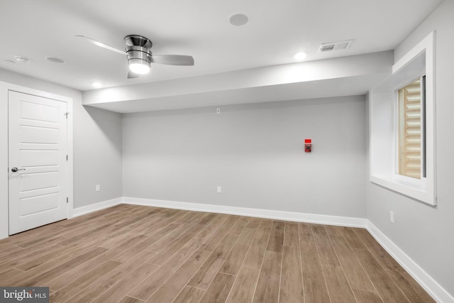 basement featuring ceiling fan and light hardwood / wood-style flooring