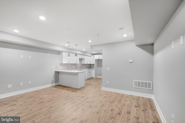 unfurnished living room featuring light wood-type flooring and sink