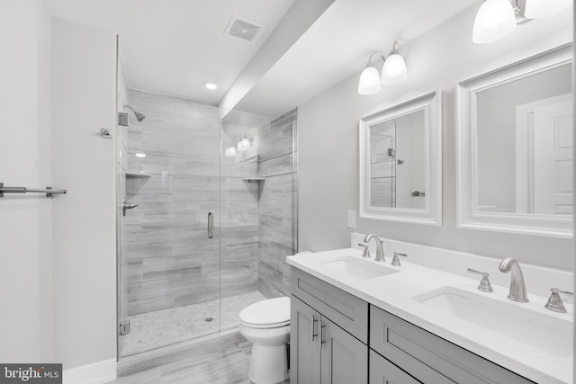 bathroom with vanity, toilet, and a shower with shower door