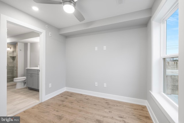 spare room with ceiling fan, a healthy amount of sunlight, and light hardwood / wood-style floors