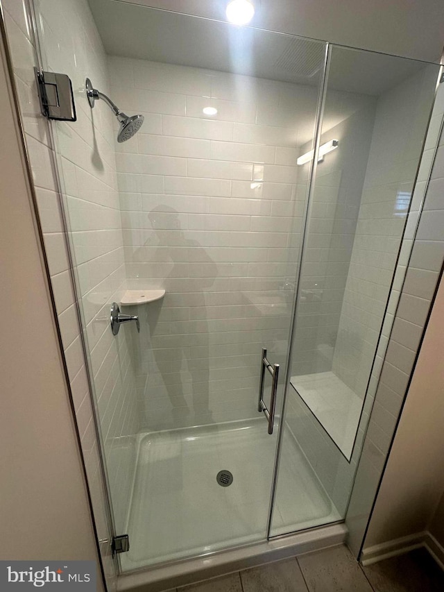 bathroom with tile patterned flooring and a shower with shower door