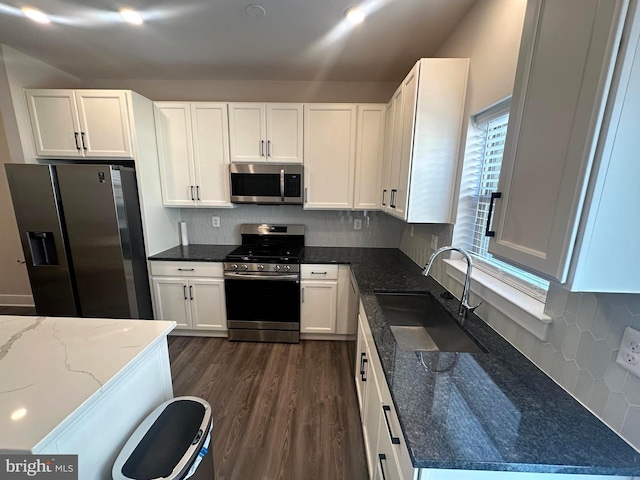 kitchen with white cabinetry, sink, dark hardwood / wood-style flooring, dark stone countertops, and appliances with stainless steel finishes