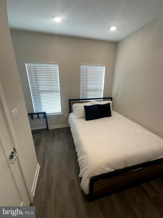 bedroom with dark hardwood / wood-style flooring