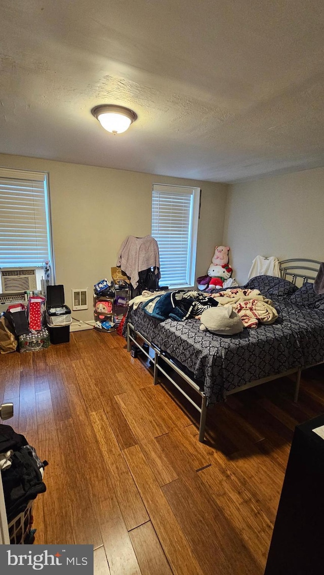 bedroom featuring wood-type flooring and a textured ceiling