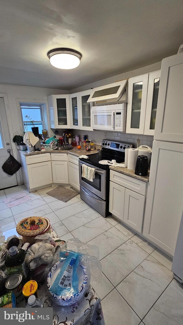 kitchen with backsplash, white cabinetry, stainless steel electric range oven, and sink