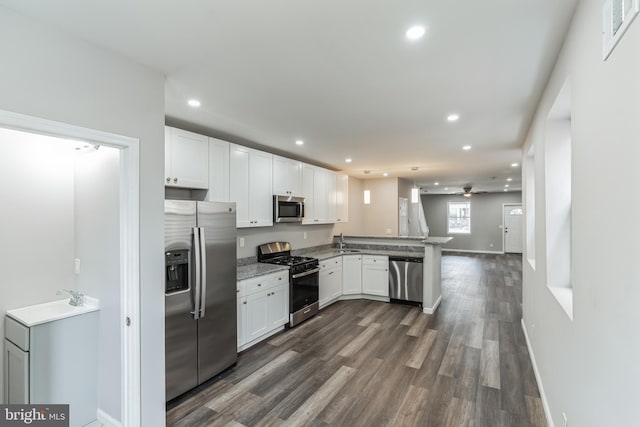 kitchen featuring kitchen peninsula, sink, white cabinets, and appliances with stainless steel finishes