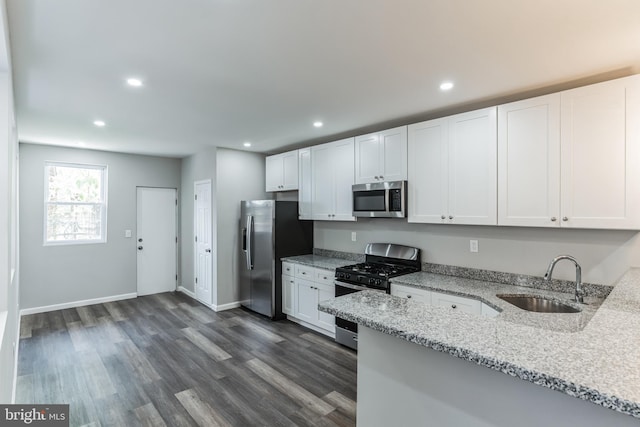 kitchen featuring light stone countertops, appliances with stainless steel finishes, white cabinets, and sink