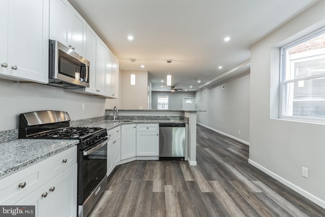 kitchen with white cabinets, ceiling fan, pendant lighting, and stainless steel appliances