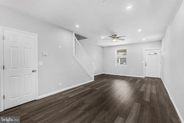 unfurnished living room featuring ceiling fan and dark hardwood / wood-style flooring