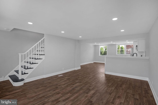 unfurnished living room featuring dark hardwood / wood-style flooring and sink