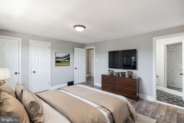 bedroom featuring multiple closets and dark wood-type flooring