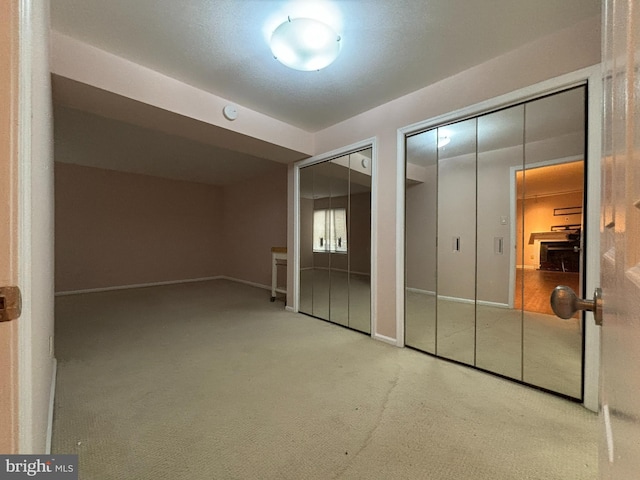 unfurnished bedroom featuring multiple closets and carpet floors