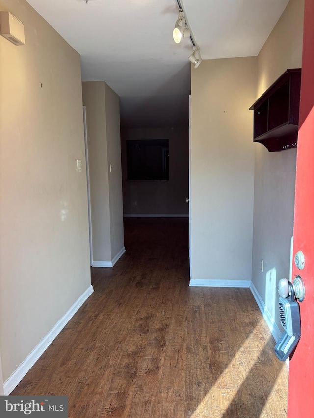 spare room with dark wood-type flooring and rail lighting