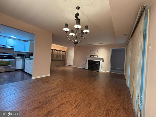 unfurnished living room featuring dark wood-type flooring and an inviting chandelier