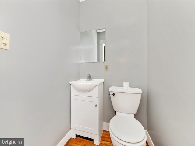 bathroom featuring vanity, hardwood / wood-style flooring, and toilet