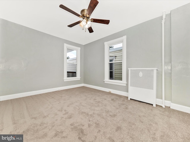 empty room featuring ceiling fan and light carpet